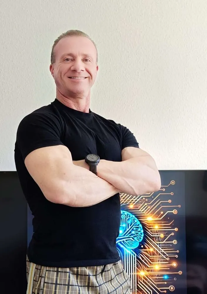 René Becker lächelnd mit verschränkten Armen